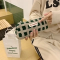 Gros plan sur la trousse en laine d'agneau gaufrée verte à damier avec étiquette blanche - Carreaux Verts