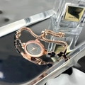 Detail view of oval rose gold quartz watch with black leaf gemstones and draw buckle - Black
