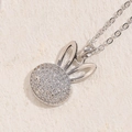 Collana con ciondolo a coniglio argentato con zirconi bianchi su superficie di pietra beige - Coniglio Argento Testa Rotonda (XL2392)