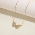 Close-up of golden butterfly necklace with pavé-set zircons and elegant fine chain - Butterfly Necklace