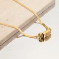 Detalle del collar de cadena de serpiente dorada con tres cuentas sobre superficie - Chapado en Oro 18K