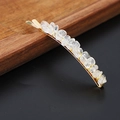 Detail of natural crystal stones set on a golden metal hairpin against a black background - Clear Quartz Gold
