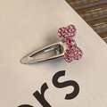 Macro detail of silver metal hair clip with pink rhinestone bow inlay on textured card - Rhinestone Bow BB Clip