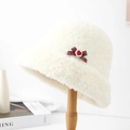 Dettaglio del cappello pescatore in peluche bianco con fiocco scozzese e bottone cuore - crema