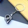 Macro view of a polished silver metal car turbocharger keychain with detailed turbine structure - Turbocharger / Black