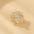 Vista macro del broche floral dorado con micro-pavé de circonitas y piedras corte marquesa - XZ3 Pétalo intrincado / Dorado con Circonita Clara