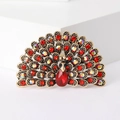 Dettaglio macro di una spilla a pavone con strass rossi e multicolori brillanti - Rosso
