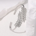 Brazalete abierto de acero plateado minimalista con diseño de hojas caladas sobre piedra - Color Acero