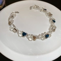 Dettaglio della collana di perle di cristallo con gemme a forma di cuore blu e champagne - Bianco/Blu