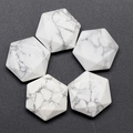 Five hexagonal white howlite crystals with grey marble veins on dark background - Howlite
