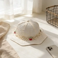 Dettaglio del cappello da sole neonato con pizzo color crema e piccoli decori a fragola - 48-50cm (5-20 Mesi) / Bianco Sporco