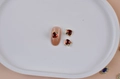 Three red heart-shaped gemstone nail charms with golden bases on a white tray - Gold Border Red Heart Gemstone