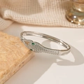 Silberne Schlangenarmspange mit grünen Edelsteinaugen und Zirkonia auf Stein - Silber