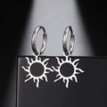 Vue détaillée de boucles d'oreilles créoles avec pendentif soleil argenté poli sur socle - Boucles d'Oreilles Soleil Acier