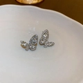 Vista macro di orecchini a farfalla con zirconi su un piatto di ceramica bianca - 5# Orecchini a Bottone a Farfalla con Strass e Perno in Argento