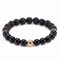 Macro detail of elastic beaded bracelet with black lava stone and gold metallic accents - Black Agate