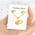 Close-up of golden stainless steel heart jewelry set with LOVE engraving and card - Double Heart Hollow LOVE (TT-081)
