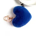 Detailed view of fluffy royal blue plush heart keychain with rose gold metal clasp - Blue