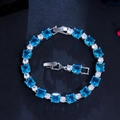 Detail view of square blue gemstones and round cubic zirconia on a tennis bracelet - Aquamarine