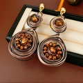 Dettaglio di orecchini vintage a goccia con perle di rame in una scatola portagioie nera - Stile Intrecciato Rotondo con Perno in Argento 925 / Marrone oro