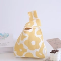 Detailed knit wrist bag featuring yellow floral pattern and unique single knot handle - Yellow-Flower