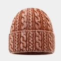 Gros plan sur la maille torsadée épaisse d'un bonnet marron avec bordure repliée chaude - Réglable / Rouge Orangé