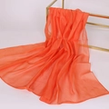 Detail view of smooth orange chiffon scarf draped on a gold stand for a soft texture - Solid Color / Pumpkin Orange