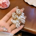 Nahaufnahme von Vintage-Perlenohrringen mit funkelnden Quasten und Gold-Finish - Silbernadel Gold Weiß