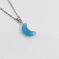 Détail d'un collier avec pendentif croissant de lune bleu poli et chaîne en métal argenté - Bleu
