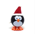 Cute wind-up Christmas penguin toy with red Santa hat and black body on white background - Wind-up Penguin with Pointed Hat