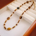Close-up of irregular tiger eye shell beaded necklace with gold accents in a wood box - 10# Tiger Eye Spliced Rectangular Round Bead Necklace
