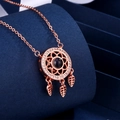 Collana acchiappasogni in oro rosa con zirconi e ciondoli a foglia su sfondo blu - Oro rosa