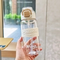 Detail of minimalist 500ml plastic sport water bottle with beige silicone sleeve and straw - White