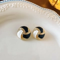 Dettaglio macro di orecchini vintage in smalto bianco e nero su un piatto di ceramica - Blocco di Colore Nero e Bianco (Perno in Argento)