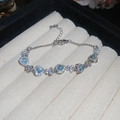 Silbernes Armband mit blauen Herz-Zirkonia-Steinen und funkelnden Schmetterlings-Anhängern - Herz-Blaustein-Blumencluster-Armband (12#) / Silber
