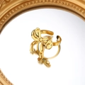 Anello con fiocco in acciaio dorato lucido su una superficie a specchio dorata vintage - Stile Fiocco