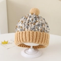 Detail van de meerkleurige gebreide muts met zachte pompon en dikke geribbelde omslag - Eén maat / Khaki