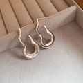 Détail de boucles d'oreilles argentées en forme de J avec effet métal liquide sur velours - Argent (Aiguille en Argent S925)