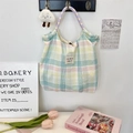 Detailed close-up of a checkered canvas tote bag with floral handles and cloud pendant - Large Plaid Stripe Green