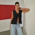 Black hollow-out knit vest with V-neck and button closure on model with jeans - S / Black