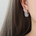 Elegant silver C-shaped grid earrings with sparkling pavé crystals on a female model - Silver Style (F942)