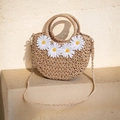 Detail der handgewebten Strohtasche mit weißen Gänseblümchen auf einer Steinfläche - Vier Kunststoffblumen-Braun