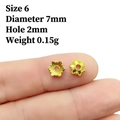Detailed view of 7mm gold hollow flower bead cap spacers on a fingertip for DIY jewelry - No.6 (Dia 7mm/Hole 2mm)