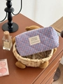 Detailed view of blue and pink checkered quilted toiletry bag on a wooden surface - Octagonal Bag (Small) / Purple