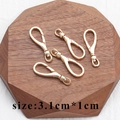 Five 18k gold plated lobster clasps for DIY jewelry making on wooden coaster - M82411 Long Gold Lobster Clasp