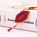 Sparkling pink rhinestone lips and lipstick keychain with golden frame on book - Purplish Red