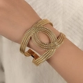 Vue détaillée d'un bracelet en fil doré torsadé à plusieurs couches sur le poignet - Bracelet corde torsadée multifil doré