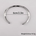 Detalle del brazalete rígido retorcido en forma de C con un diámetro interior de 6cm - Diámetro Interior 6,8 cm / Color Acero