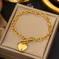 Detailed view of a gold heart pendant bracelet with OT toggle clasp on beige leather - Gold Heart OT Buckle Bracelet (JX728)
