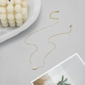 Detail of gold double heart pendant necklace with shimmering crystals on elegant plate - Twin Heart Necklace - Gold